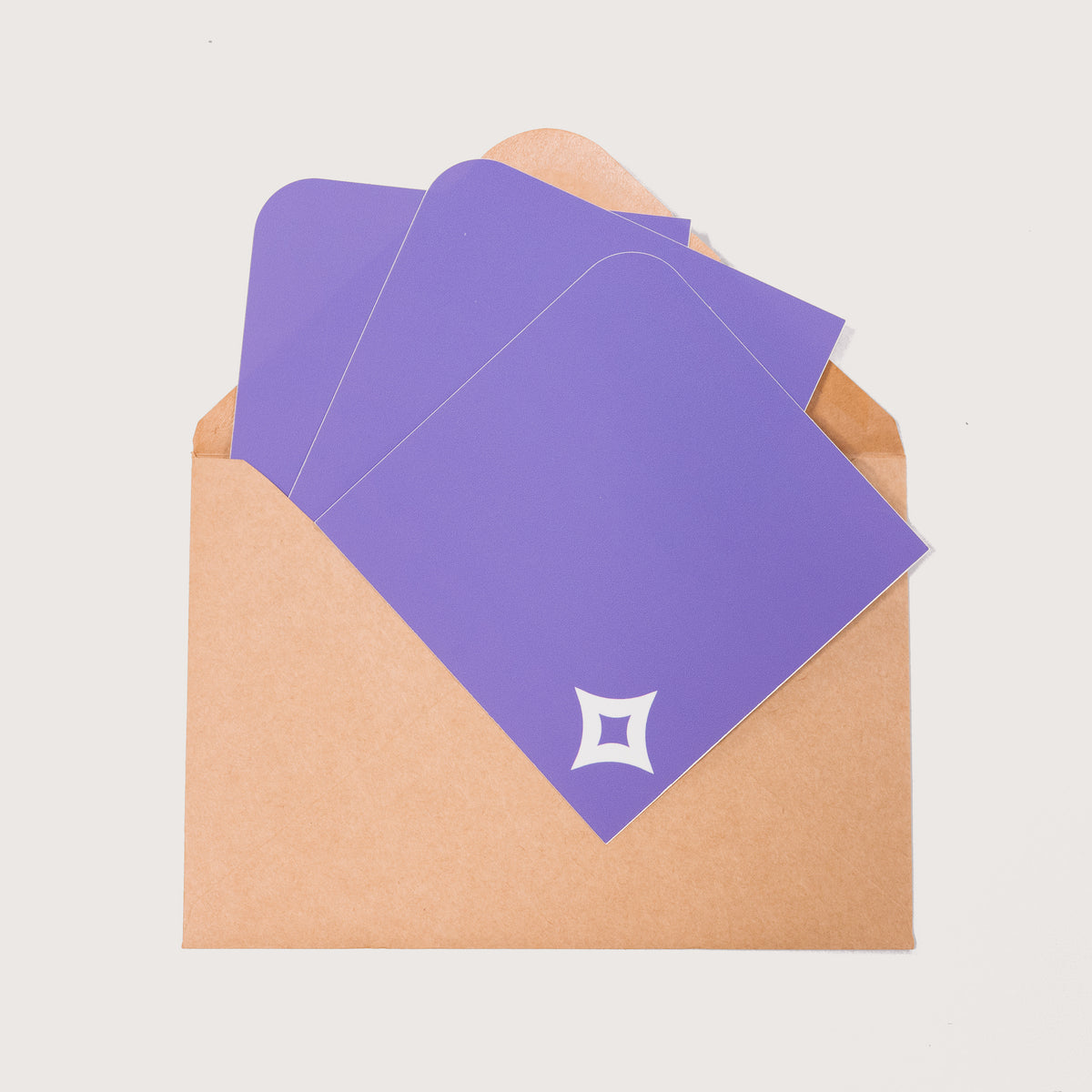 A array of Pocket Stickers with a white diamond motif photographed against a brown kraft envelope.