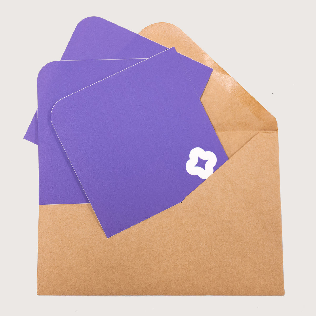 A array of Pocket Stickers with a white flower motif photographed against a brown kraft envelope.