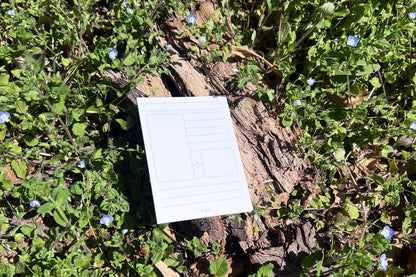 The Archivist Sticky Note pad photographed against the vibrant green and indigo of living Speedwell flowers.