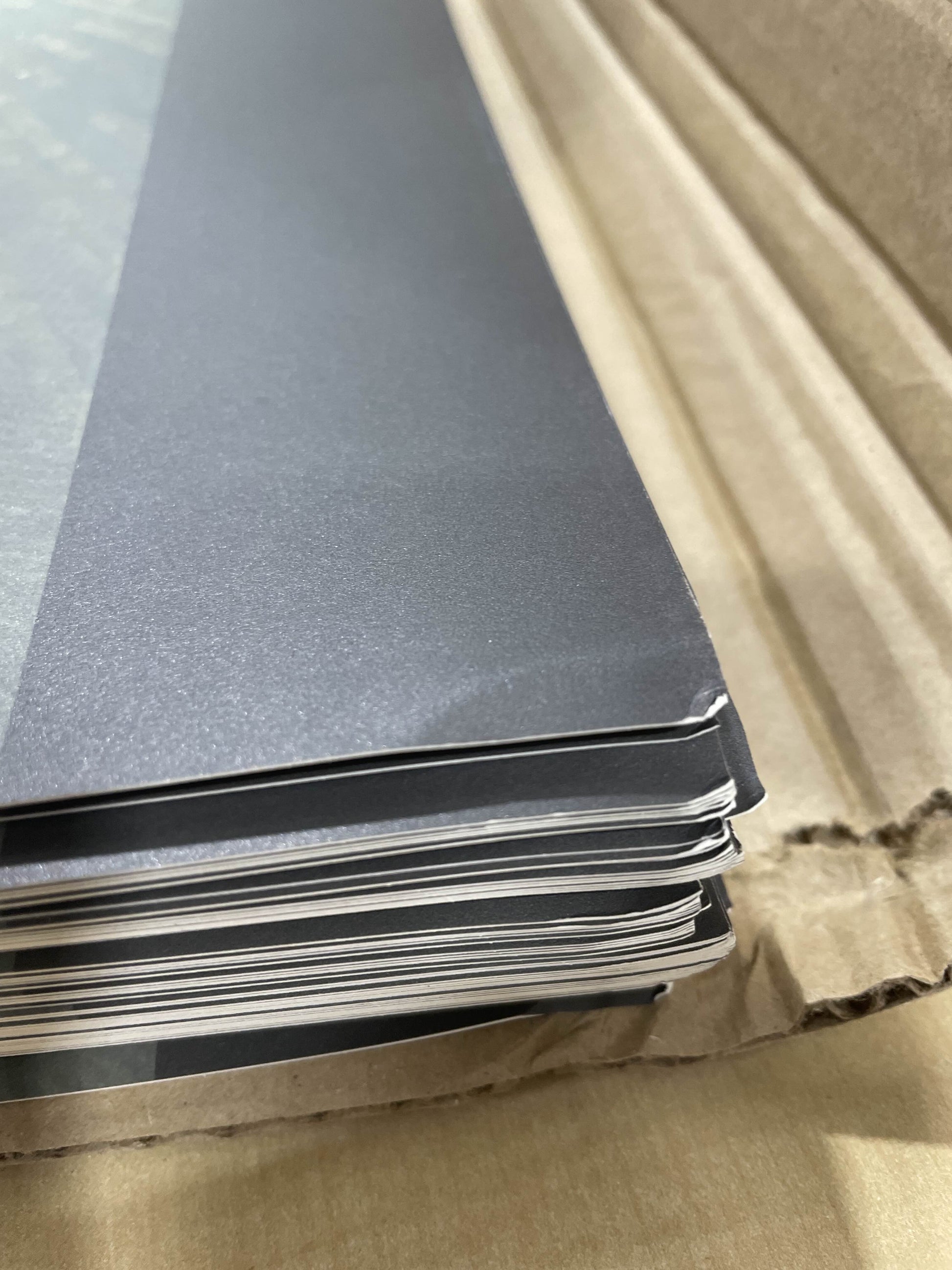 A closeup photo of the top corners of the B-Grade Solas Standard Prints. The corners are slightly folded or wrinkled, but the damage does not reach the artwork itself.