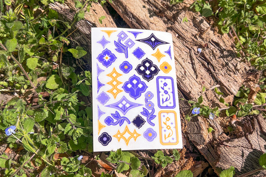 A single sheet of Speedwell Art Stickers photographed against the vibrant green and indigo of living Speedwell flowers.