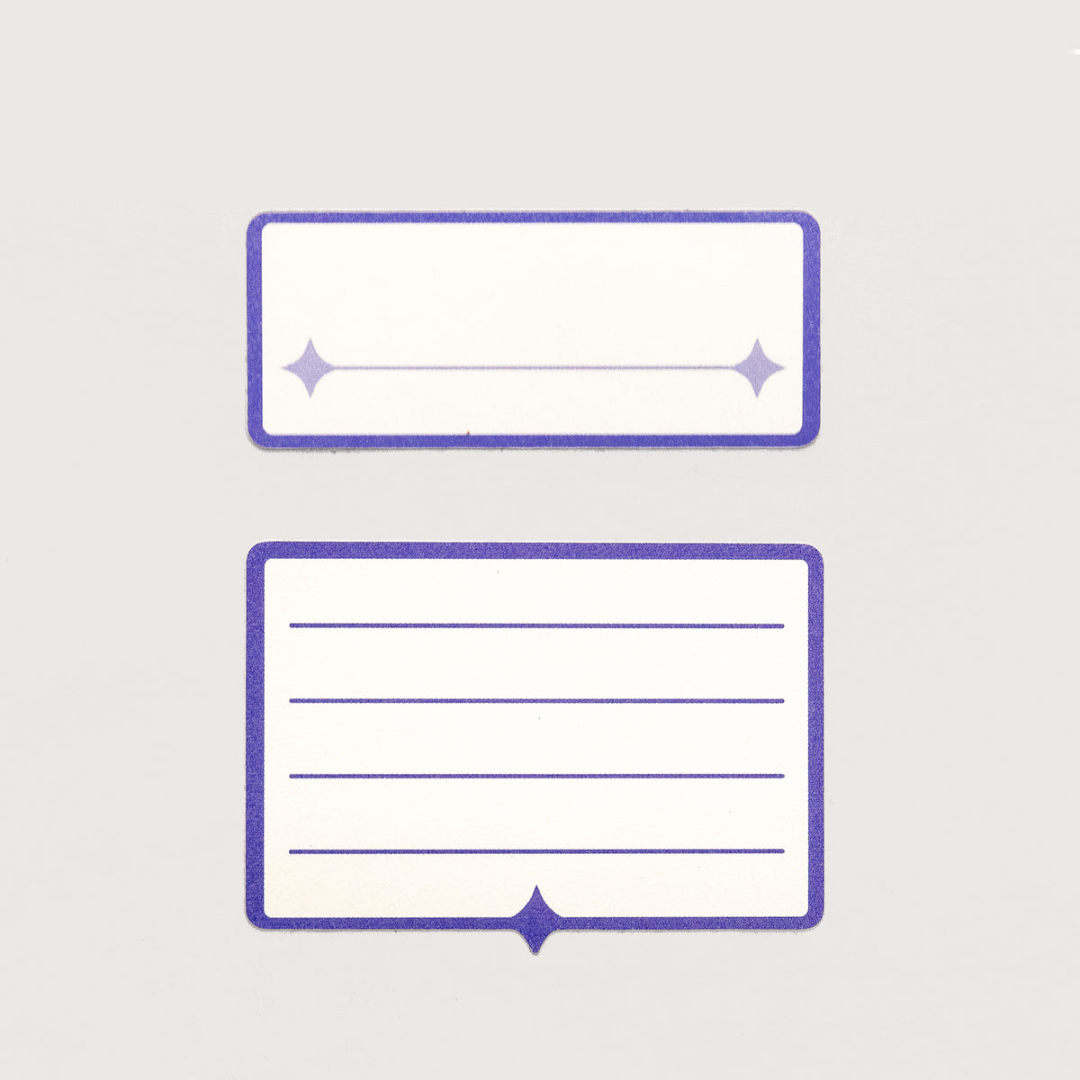 Two white and indigo label stickers. The first features a single line for written text. The second has four lines for written text.