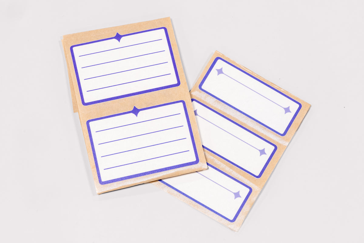 An arrangement of white and indigo Nameplate Stickers on a white background.