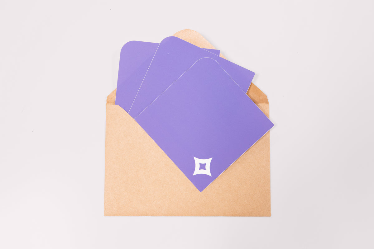 A array of Pocket Stickers with a white diamond motif photographed against a brown kraft envelope.