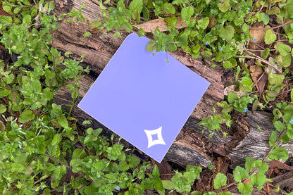 A single Pocket Sticker with white diamond motif photographed against living speedwell flowers.