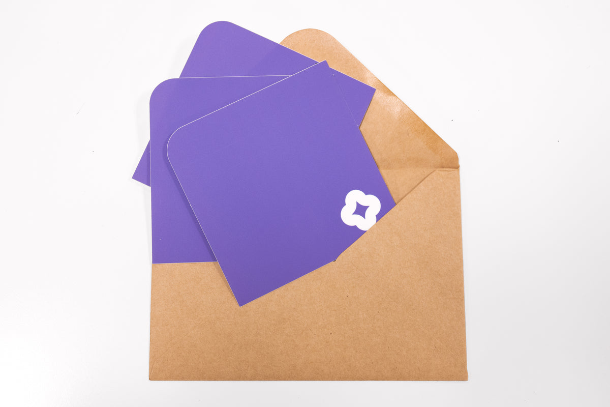 A array of Pocket Stickers with a white flower motif photographed against a brown kraft envelope.