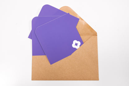 A array of Pocket Stickers with a white flower motif photographed against a brown kraft envelope.