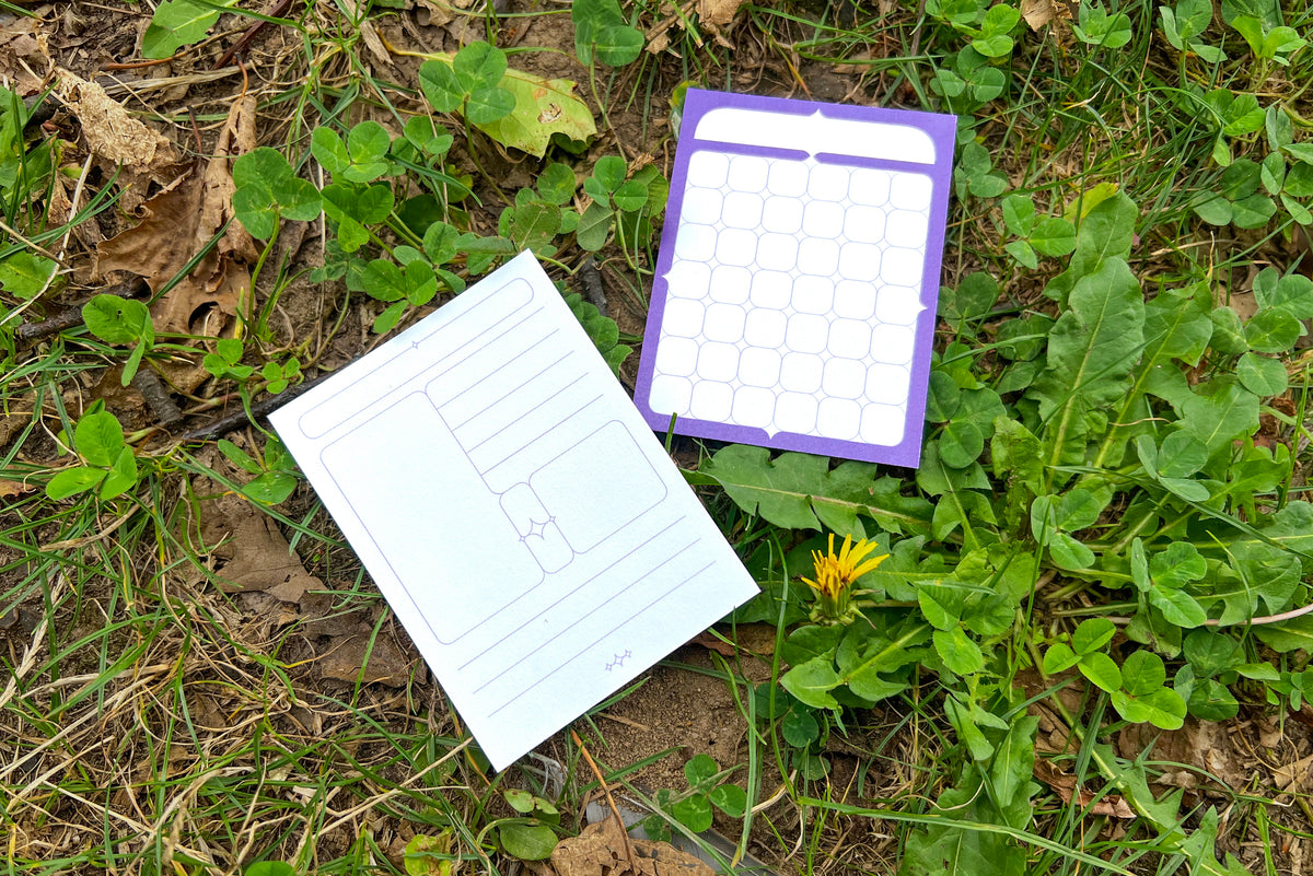 The Archivist Sticky Note and Calendar Sticky Note photographed together against a bed of dandelions.