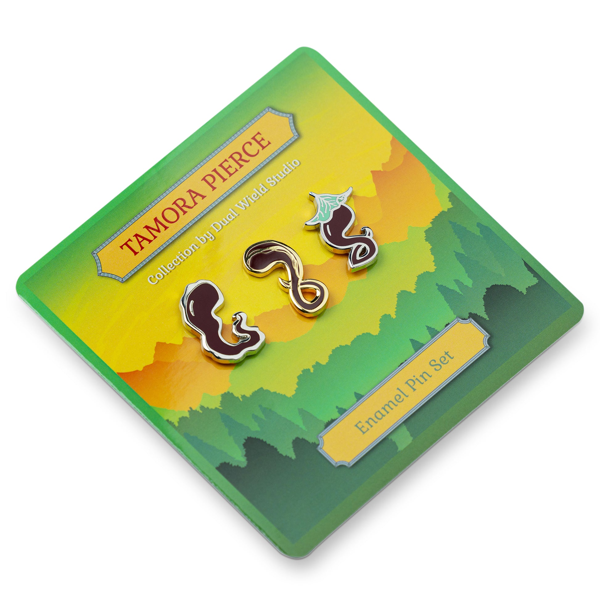 Angled view of all three Darking enamel pins on green Tamora Pierce backing card. White background.